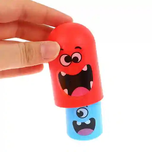 Toy capsule with cartoon face design held by a hand on a white background
