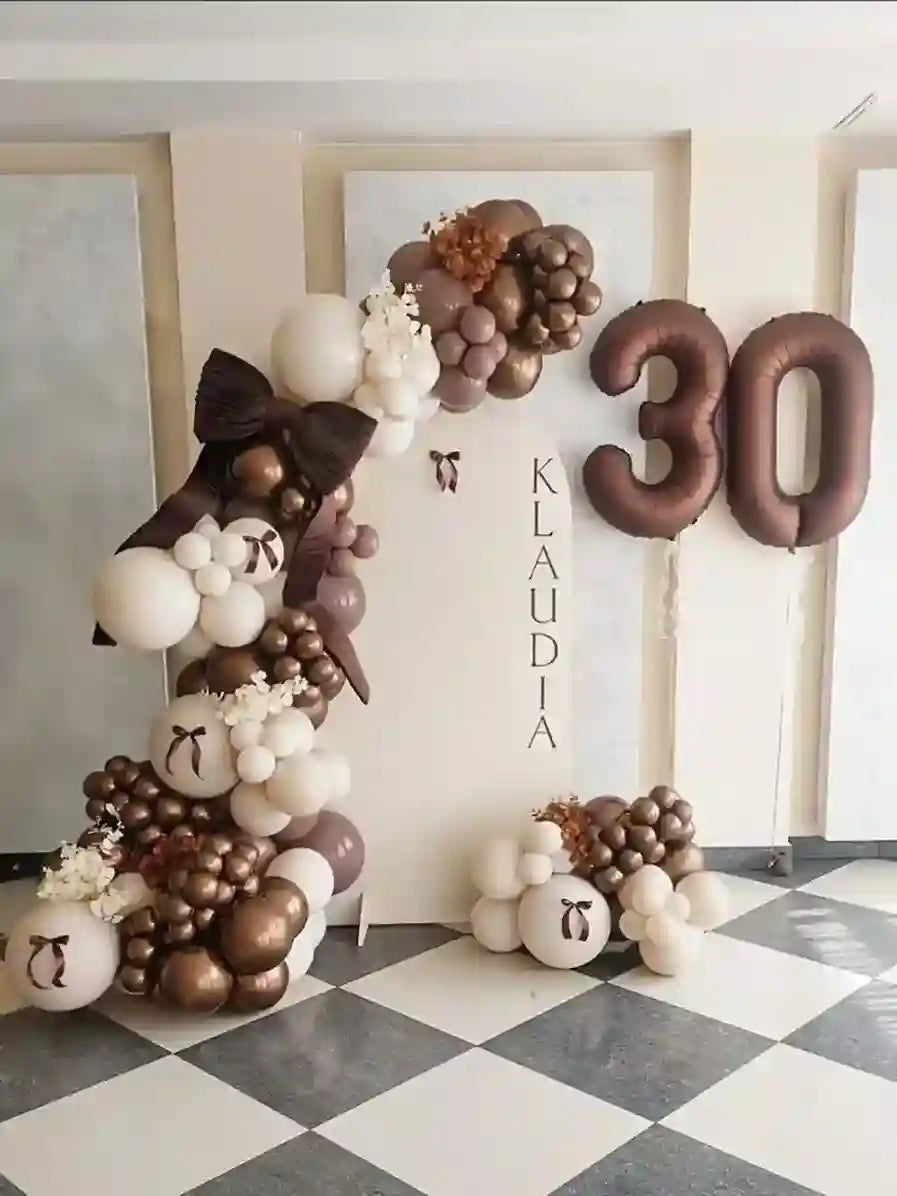 Balloon arch with number 30 and name Klaudia on a checkered floor.