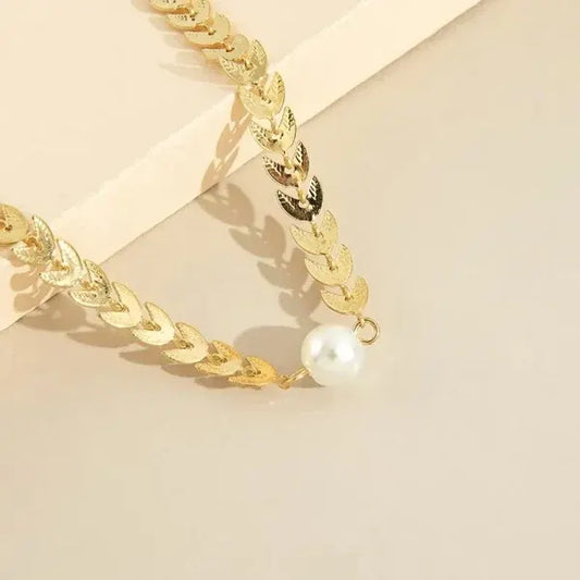 Gold chain bracelet with a pearl on a beige background