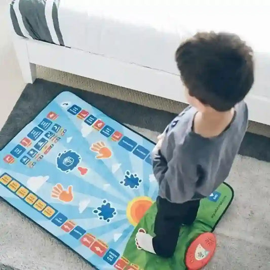 Child playing on a colorful interactive mat in a living room.