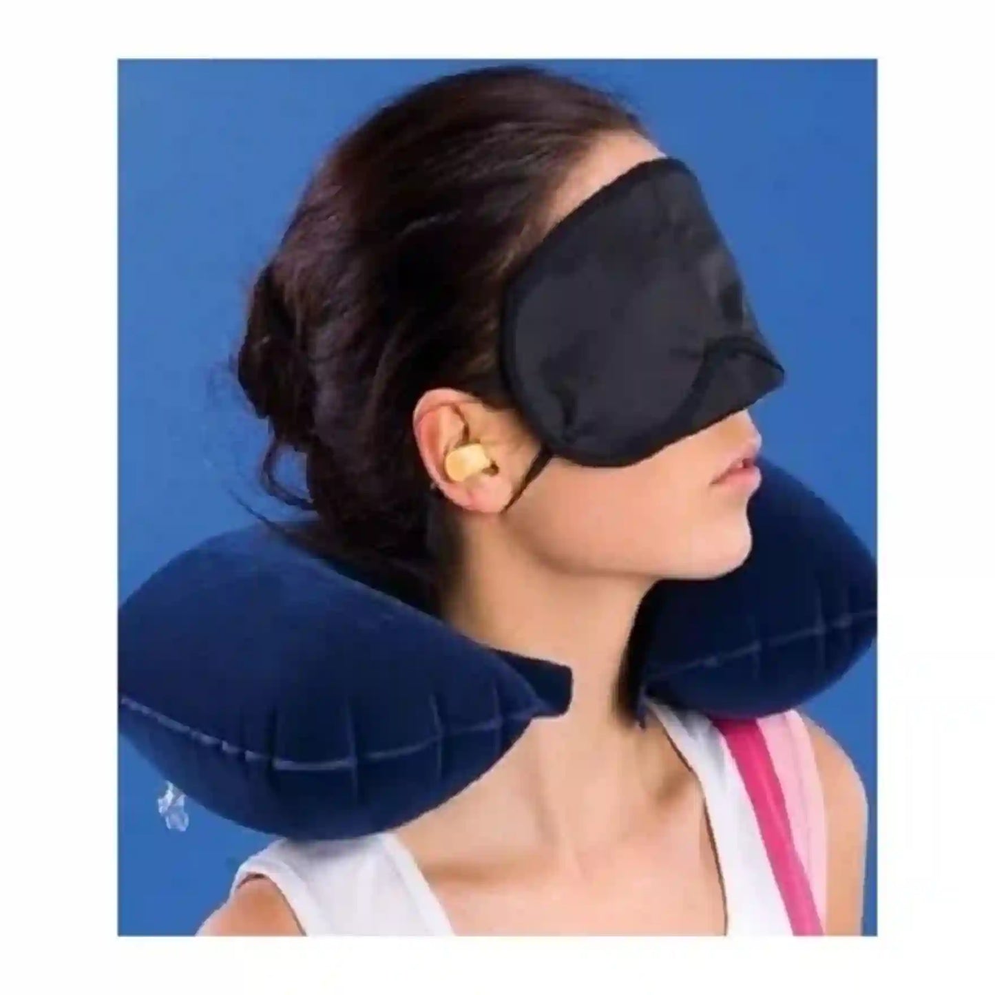 Woman wearing a black eye mask and blue neck pillow against a blue background
