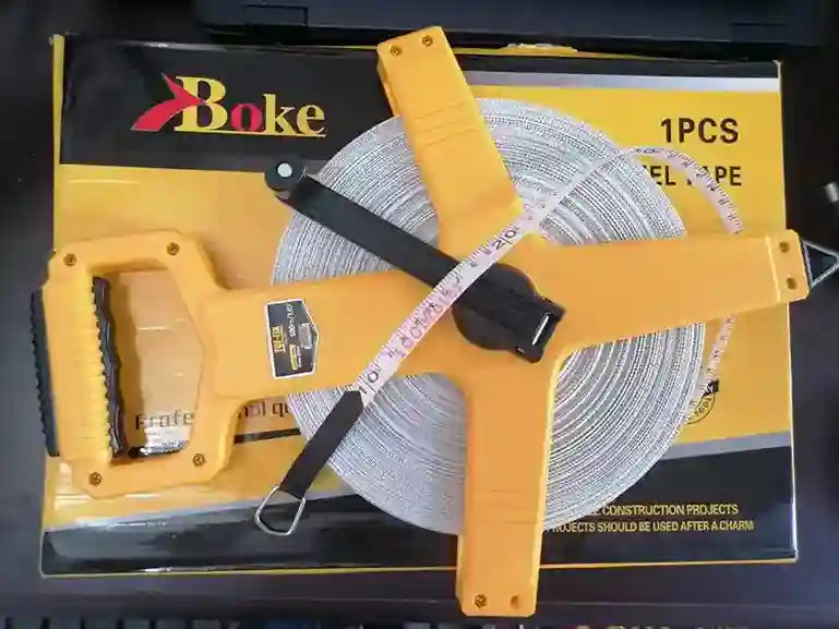 Yellow roll of cable with measuring tape on a black box labeled 'Bake'.