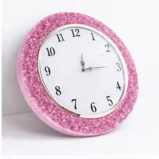 Pink glittery wall clock on a white background