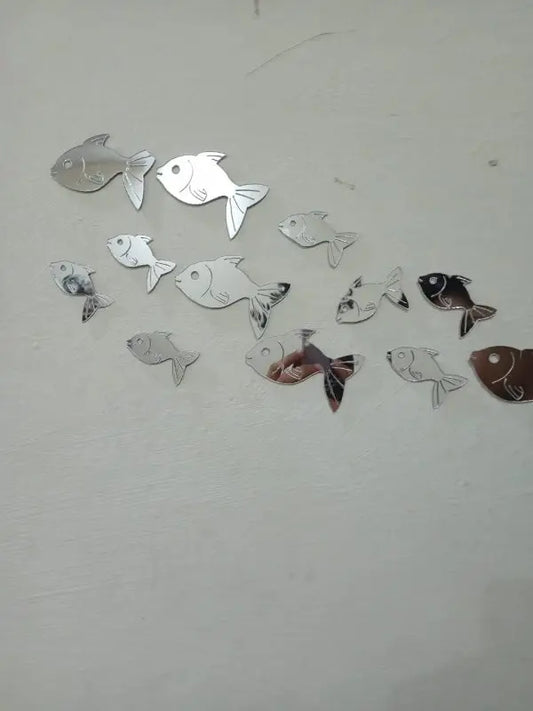 Fish-shaped mirror stickers on a white wall