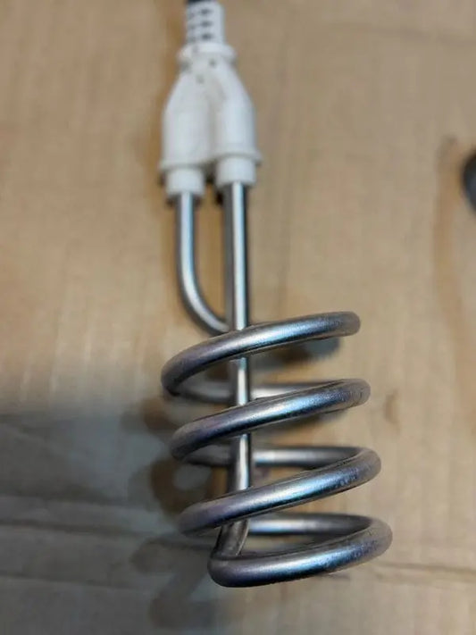 Metal heating element with power cord on a wooden surface