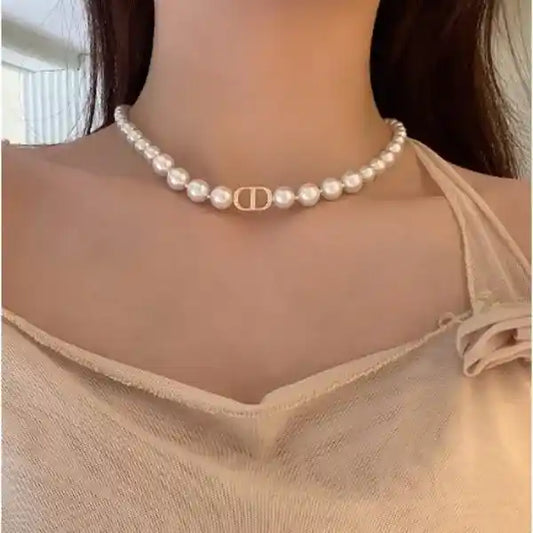 Pearl necklace worn by a person with a neutral background