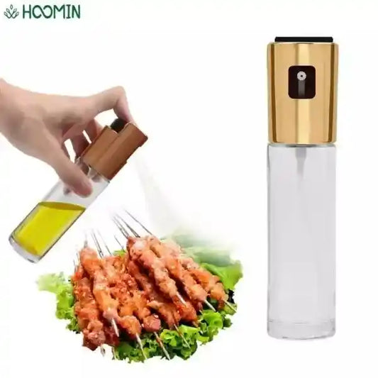 Olive oil sprayer being used on skewered food with Hoomin branding.