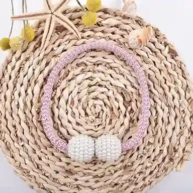 Necklace with white beads and pink accents on a woven mat