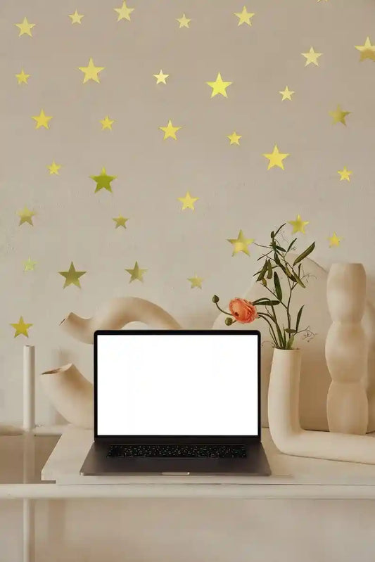 Laptop on a desk with decorative wall featuring star decals