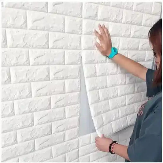 Person applying white 3D brick-patterned wall panels to a wall.