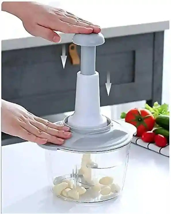 Hand using a garlic press with a container of chopped garlic on a kitchen counter.