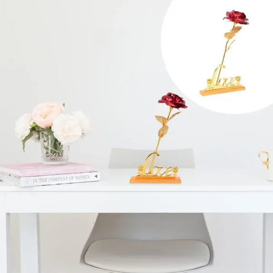 Decorative red roses with gold bases on a white surface