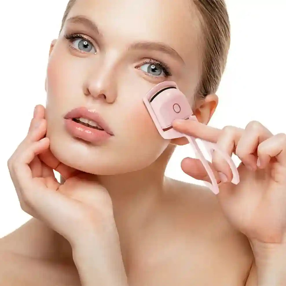 Woman using a pink facial roller on her face against a white background