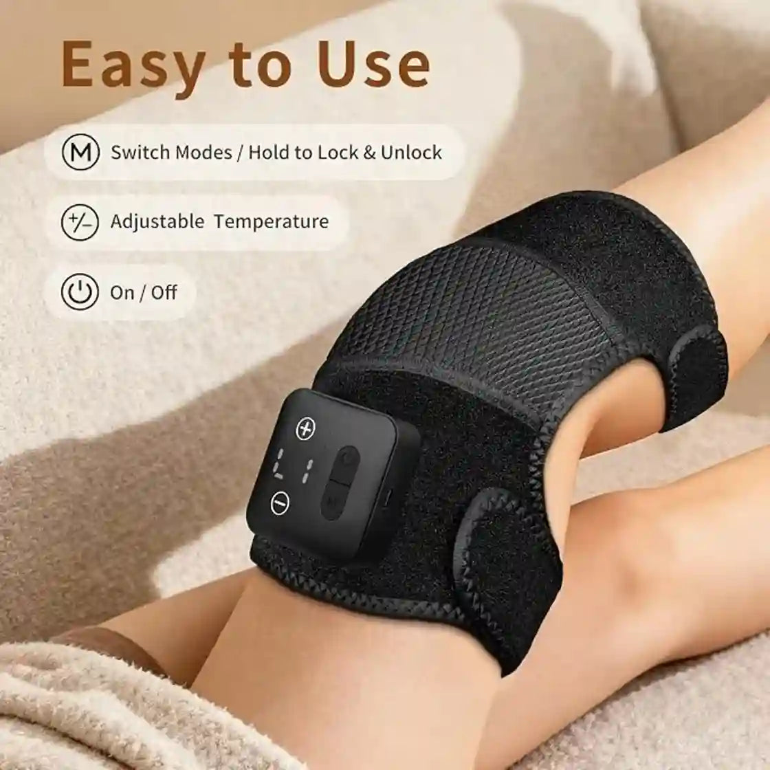Black knee brace with control panel on a person's knee, on a beige surface.