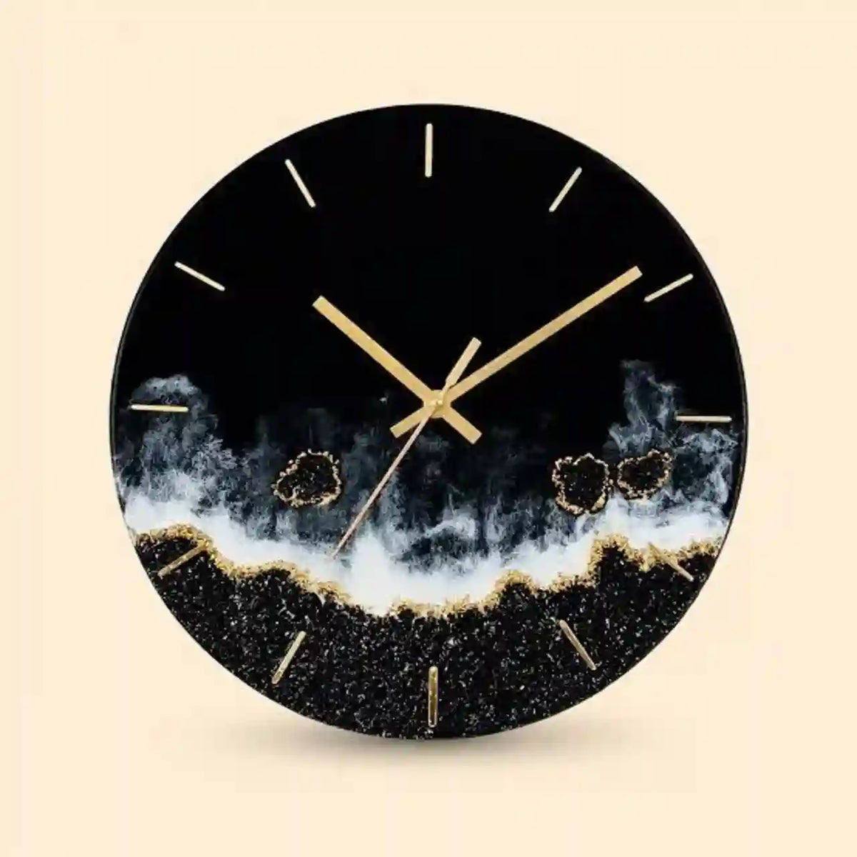A round wall clock with a black face and frame, featuring gold hands, gold hour markers, and a textured black-and-white geode or smoky wave design near the bottom, shown on a light beige background.