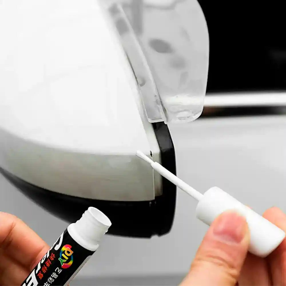 Person applying a white substance to a car's mirror with a applicator