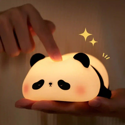 Panda-shaped night light being held with a hand touching it, against a warm background.