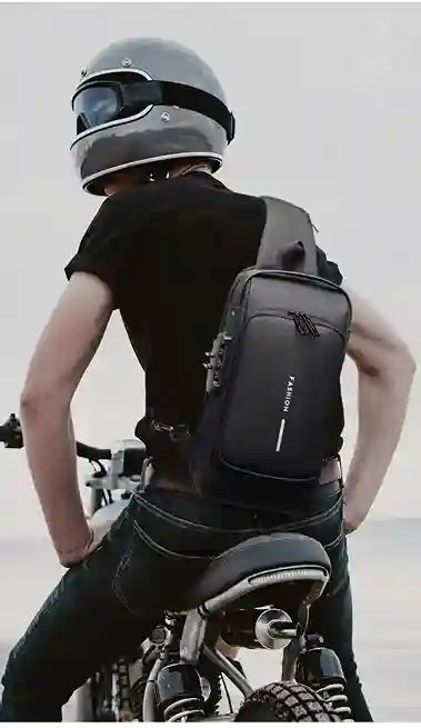Person wearing a black backpack and helmet, sitting on a motorcycle with a blurred background