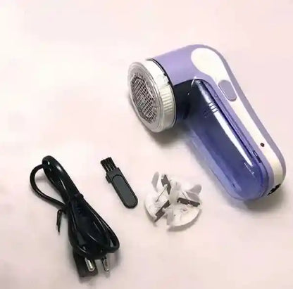 Purple fabric shaver with attachments on a light background