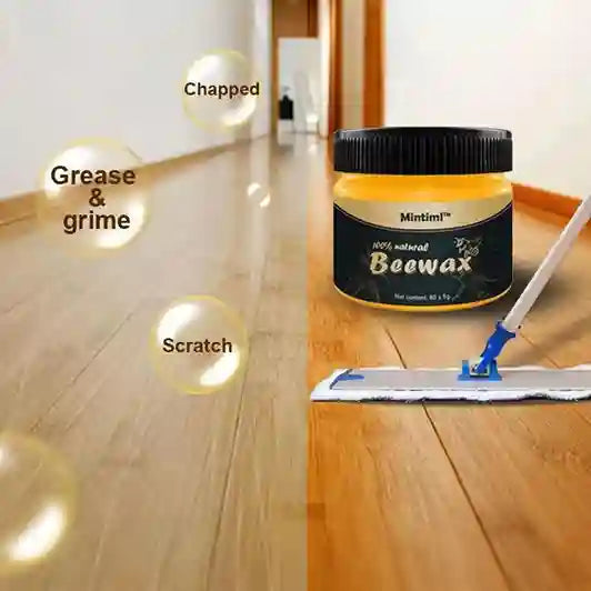 Beewax jar with a mop on a wooden floor with visible damage areas.