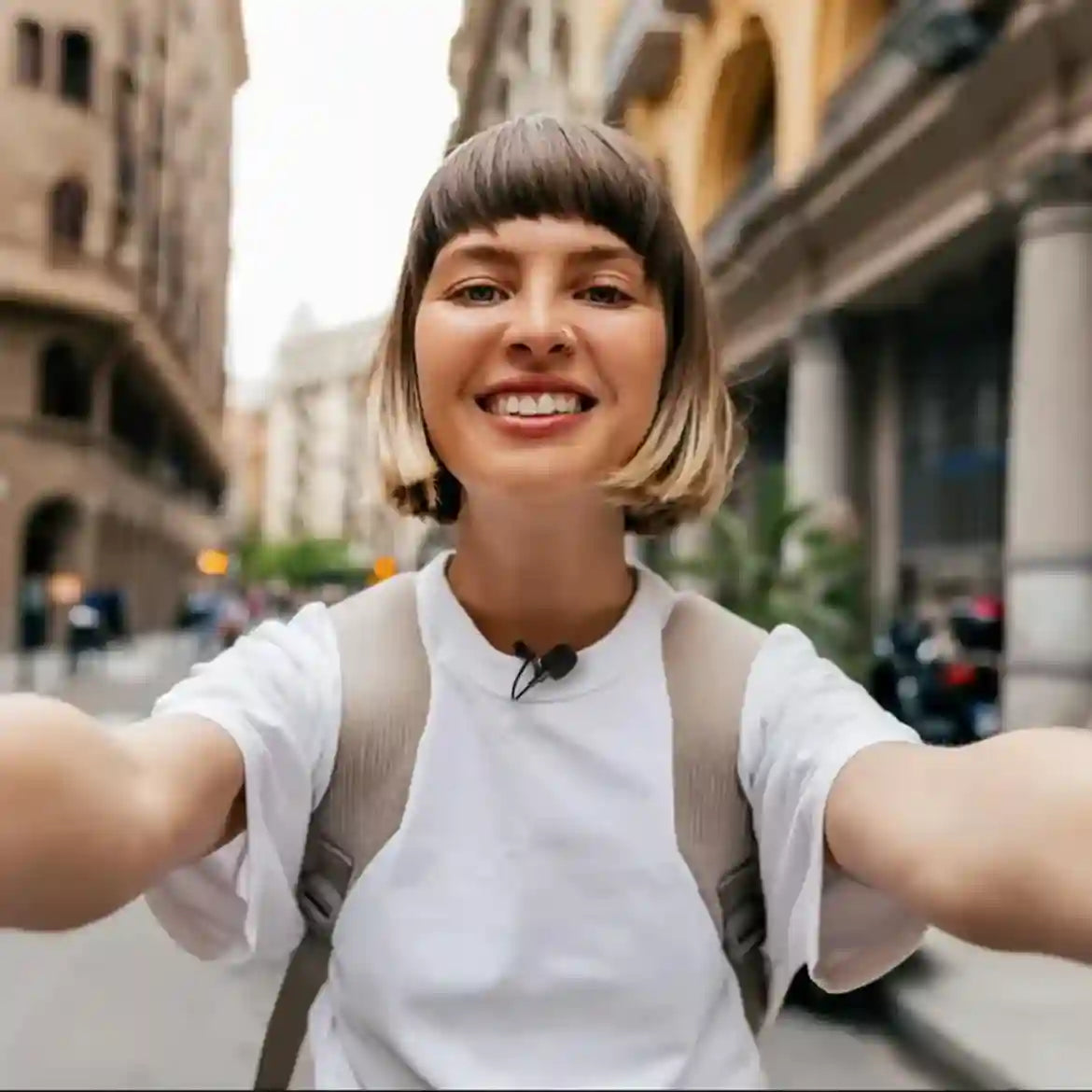 Woman taking a selfie in an urban setting with buildings in the background