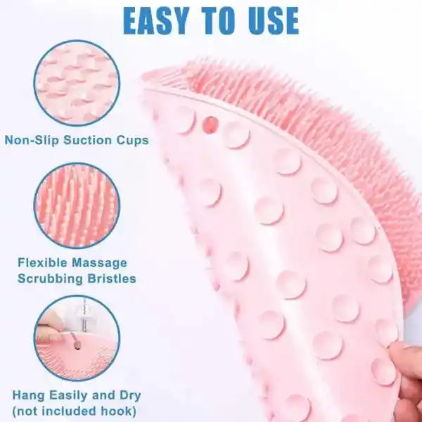 Pink scrubber with non-slip suction cups and flexible massage scrubbing bristles, held by a hand.