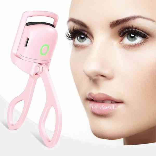 Pink eyelash curler next to a close-up of a woman's face with makeup.