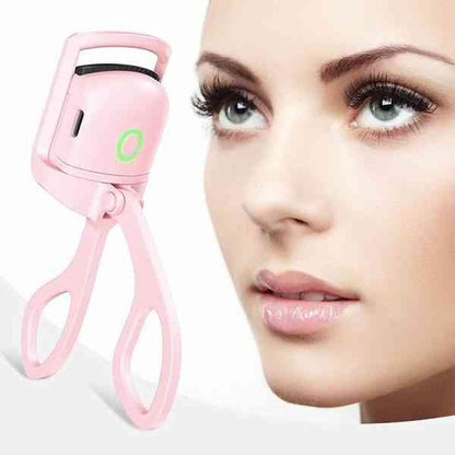 Pink eyelash curler next to a close-up of a woman's face with makeup.