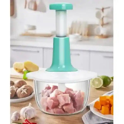 Kitchen tool with a glass container holding chopped meat, surrounded by kitchen items.