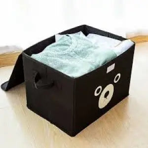 Black bear-shaped storage box with a white interior on a light wooden surface.