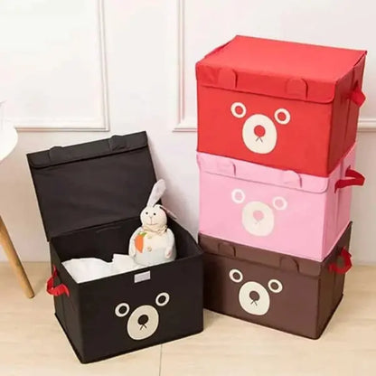Set of colorful storage boxes with bear faces on a light wooden floor.
