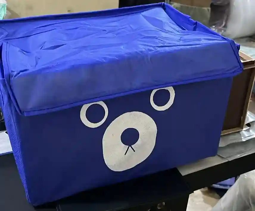 Blue storage box with a bear face design on a table