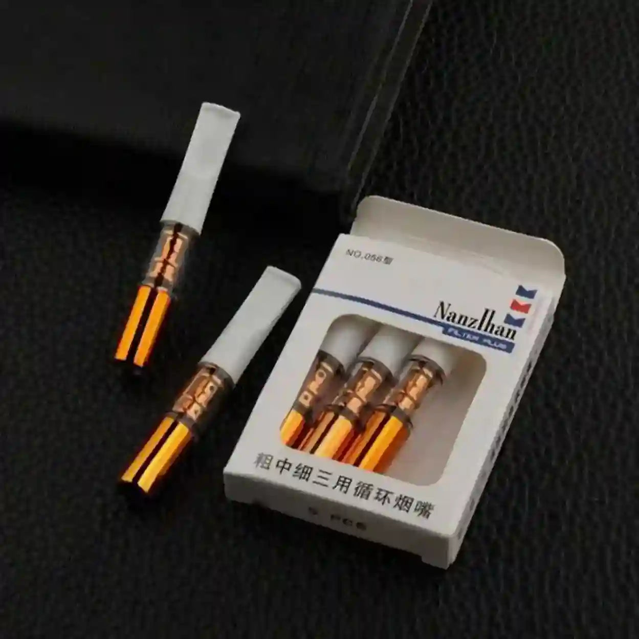 Two vape cartridges and their packaging on a dark textured surface