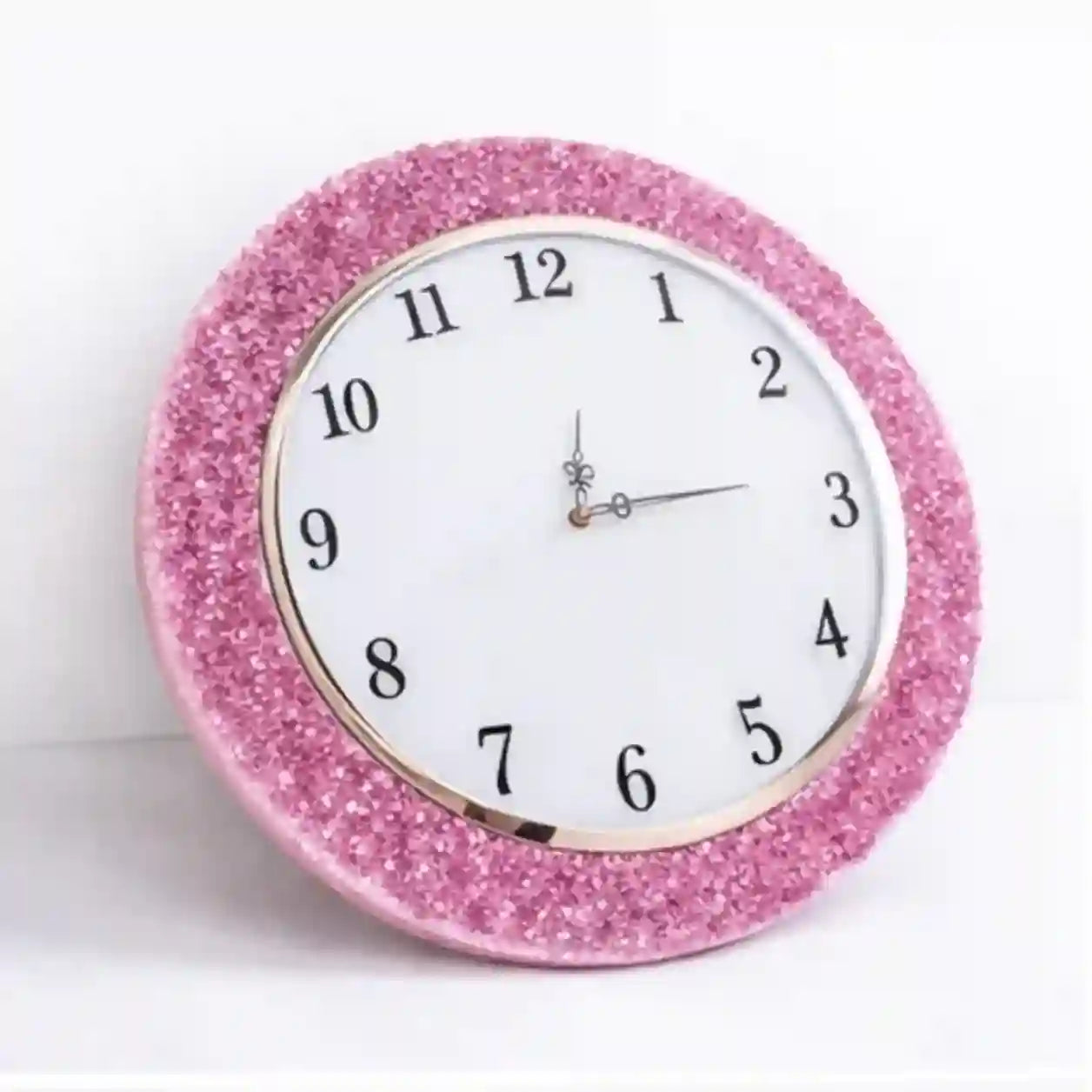 Pink glittery wall clock on a white background