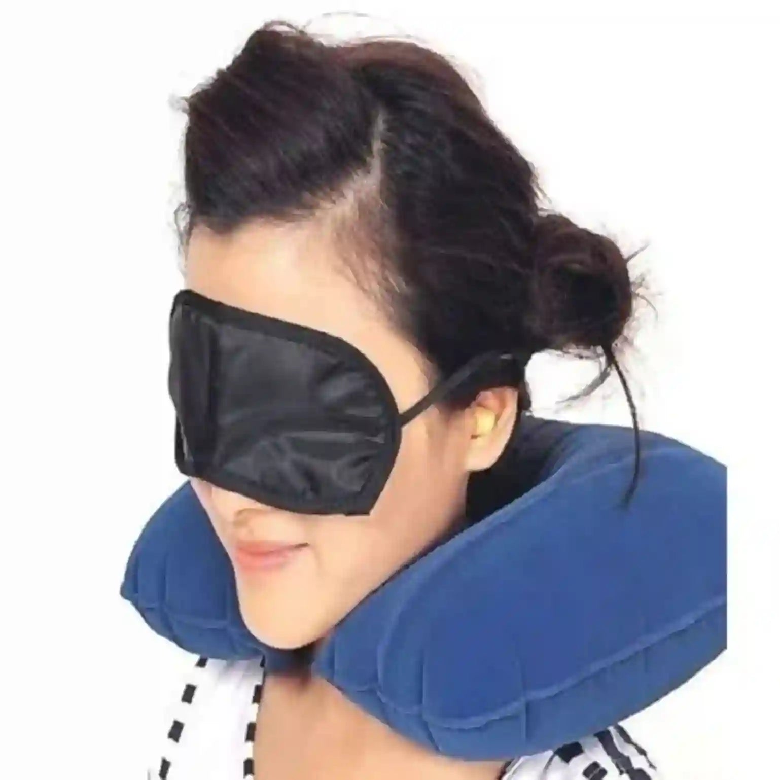 Person wearing a blue travel pillow and black eye mask on a white background