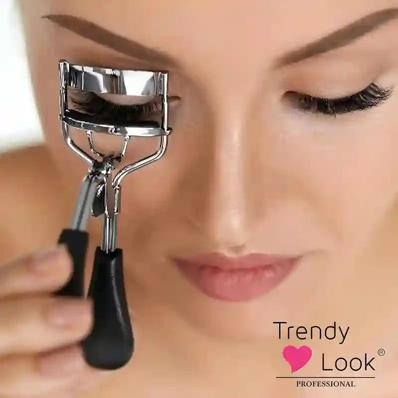 Eyelash curler held near a person's eye with 'Trendy Look' branding.