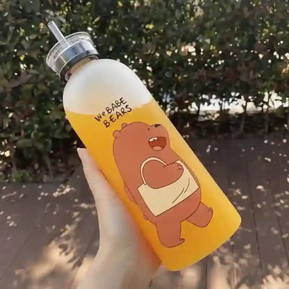 Yellow water bottle with bear design held by a hand outdoors