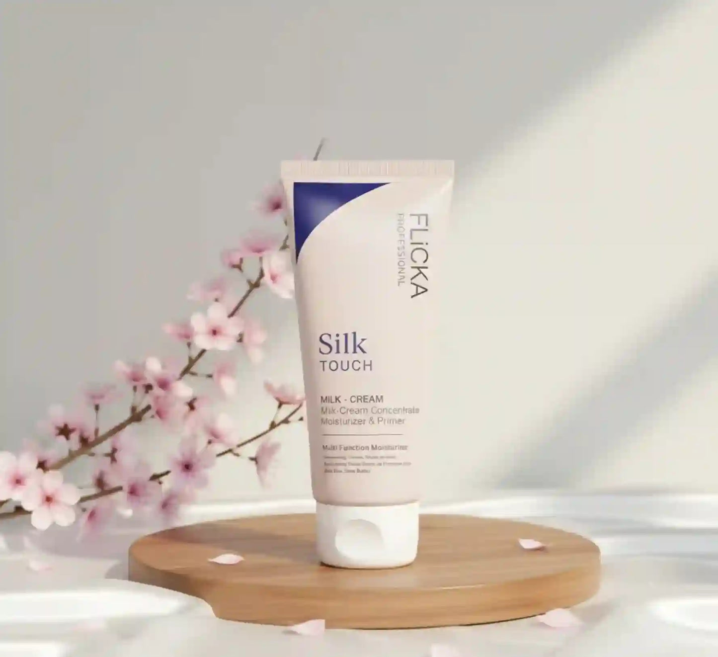 Flicka Silk Touch milk cream tube on a wooden board with cherry blossoms in the background