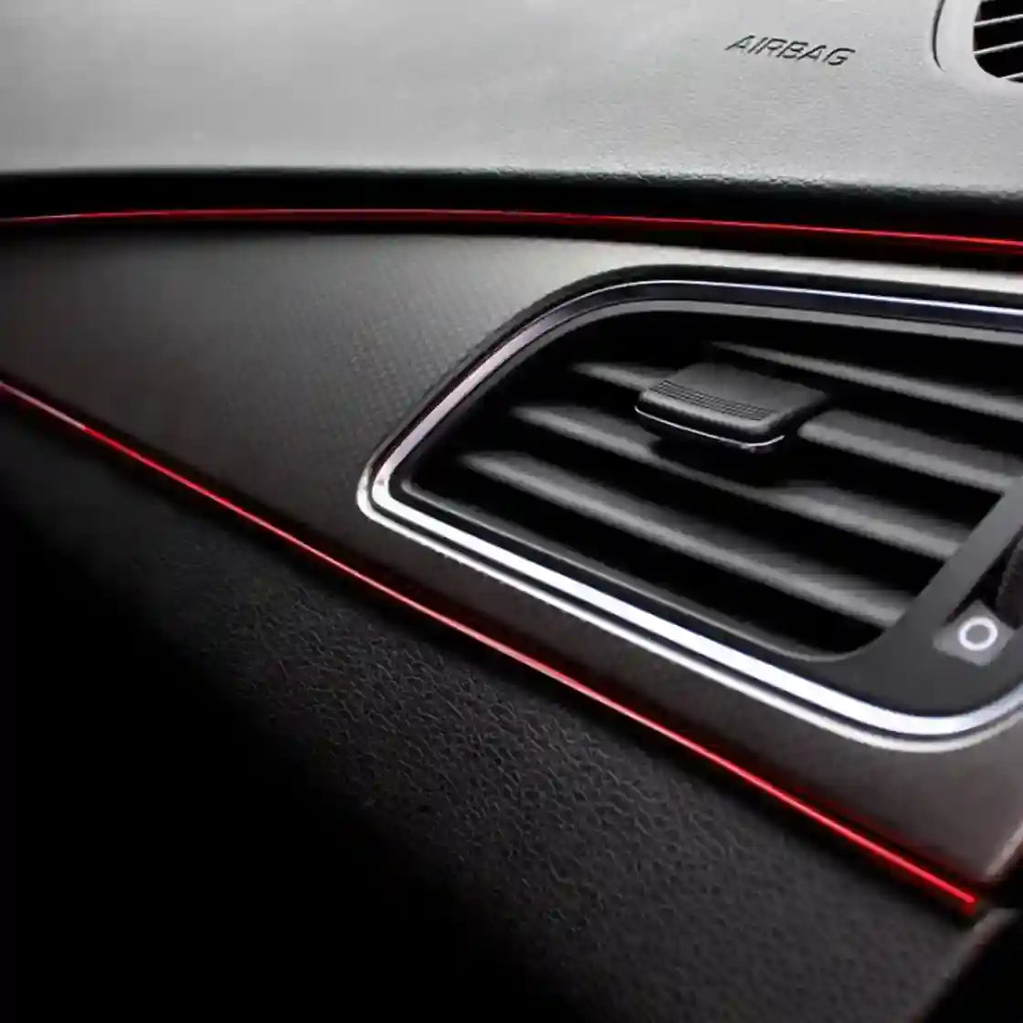 Car interior air vent with red accent lighting