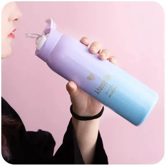 Gradient purple to blue water bottle held by a person against a pink background