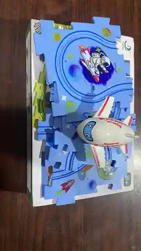Toy airplane on a colorful cardboard track with a cartoon character in the center.