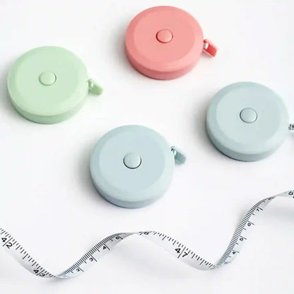 Four retractable measuring tapes in pastel colors on a white background