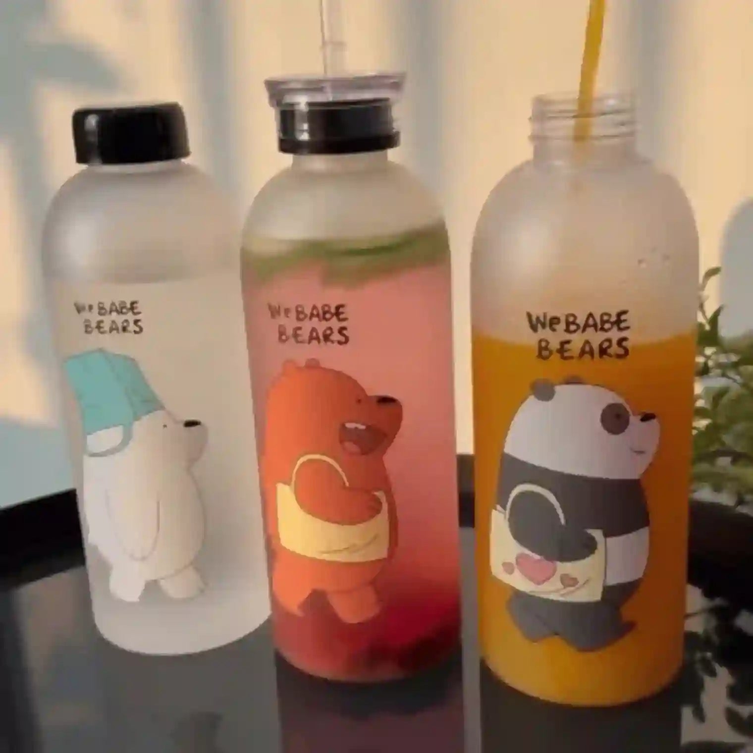 Three water bottles with cartoon bear designs and 'We Babe Bears' text on a reflective surface.