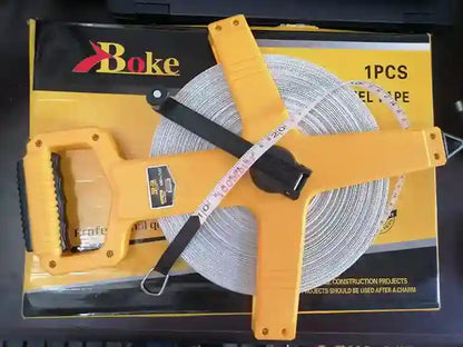Yellow roll of cable with measuring tape on a black box labeled 'Bake'.
