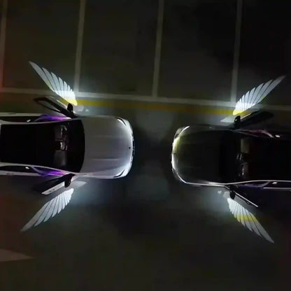 Two cars with angel wing designs on a dark floor.