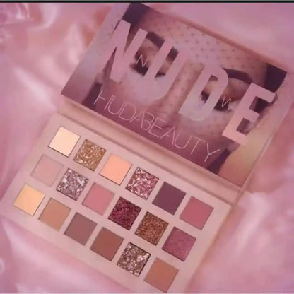 Huda Beauty nude makeup palette on a pink satin background