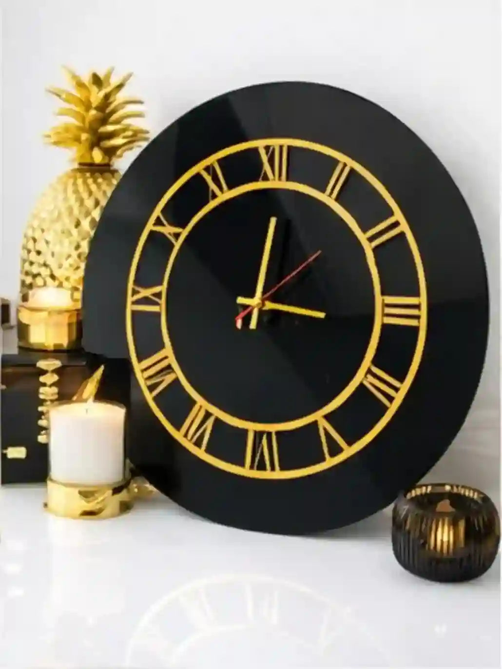 Black wall clock with gold Roman numerals on a decorative background