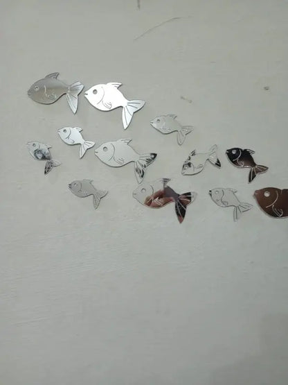 Fish-shaped mirror stickers on a white wall