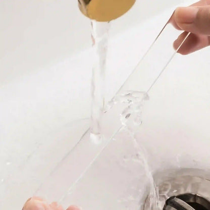Clear plastic bag with a gold handle being held over a sink.