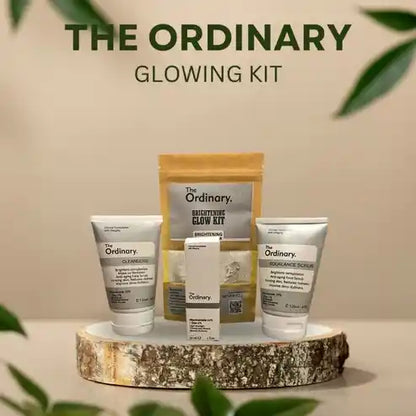 The Ordinary glowing kit with skincare products on a wooden platform against a beige background.